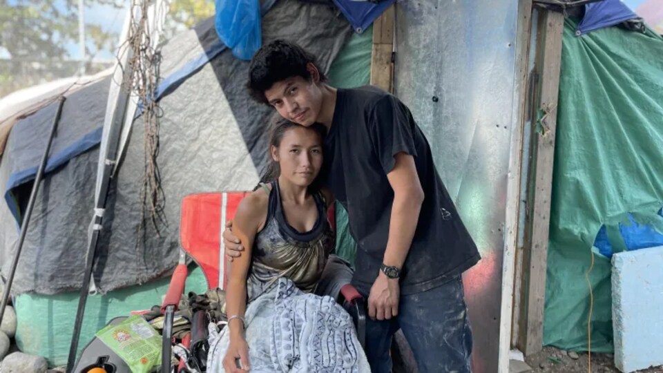 Un homme et une femme devant un tente en ville.