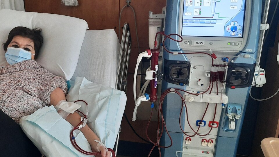 Une femme couchée sur un lit d'hôpital reçoit des traitements d'hémodialyse.