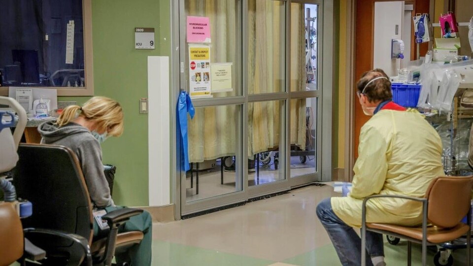 Une infirmière et une bénévole de Services de santé Alberta sont assises dans un couloir d'hôpital.