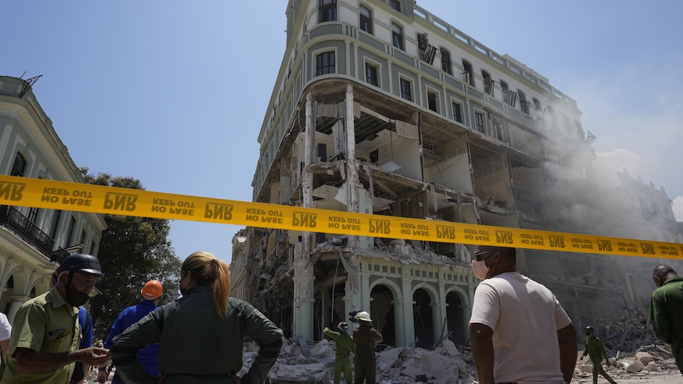 Des secouristes travaillent près de l'hôtel en ruine.