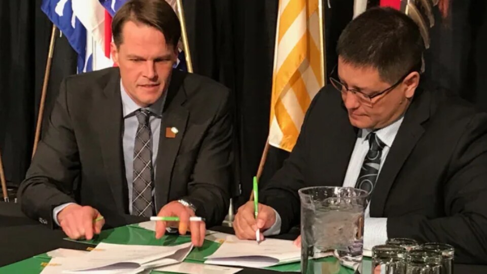 Deux hommes signent un document. (archives)