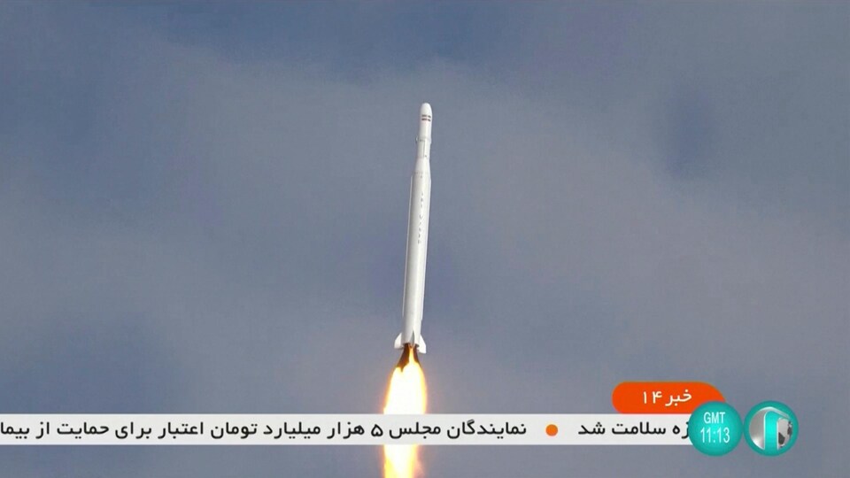 Un missile est dans les airs alors qu'une bande défilante télévisuelle écrit en perse apparaît sur l'écran.