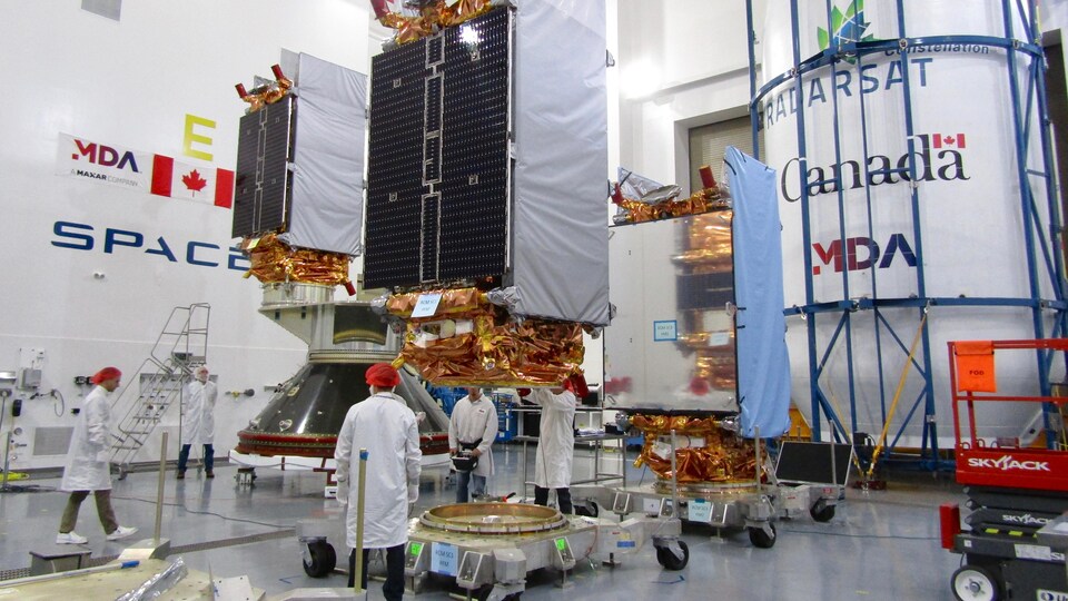 Des ingénieurs préparent les trois satellites de la mission de la Constellation RADARSAT aux à la base aérienne Vandenberg en vue de leur lancement.