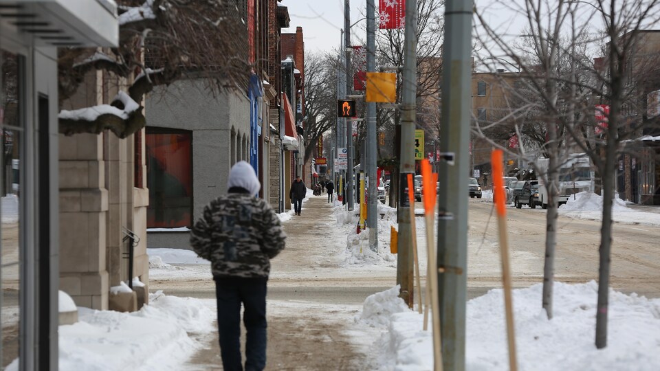 Des piétons marchent sur le trottoir de la rue Queen Est, au centre-ville de Sault-Sainte-Marie.