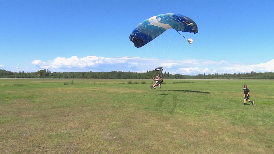 Des parachutistes atterrissent au sol.