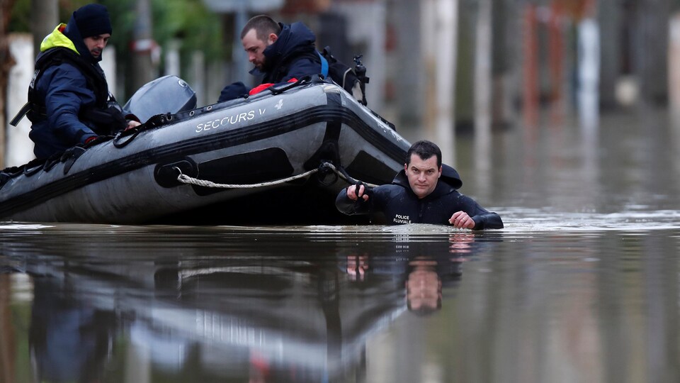 Des policiers français dans une rue inondée.