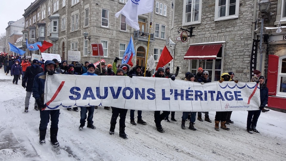 Une centaine de manifestants brandissent des pancartes dans les rues du Vieux-Québec.