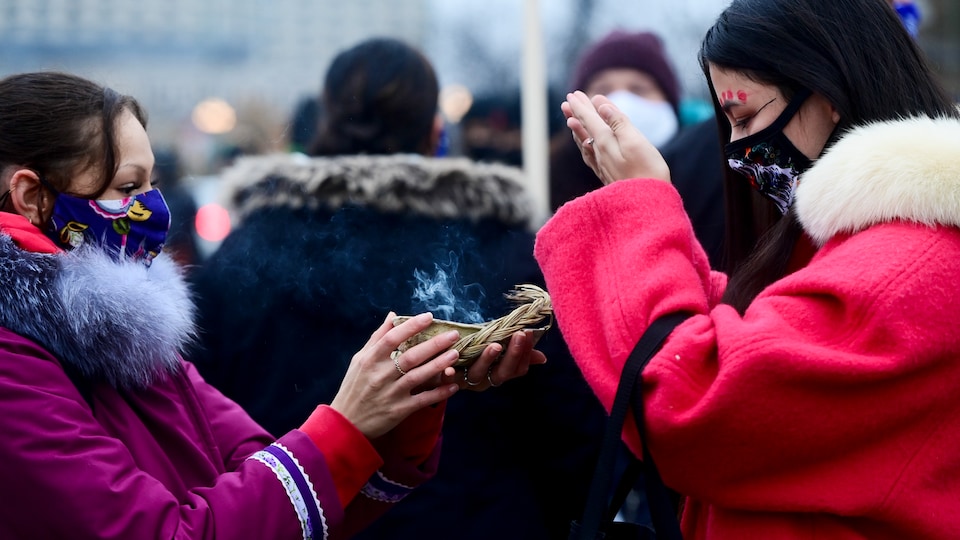 Deux femmes font un rituel autochtone.