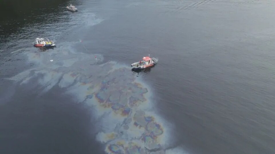 Une nappe d'hydrocarbures provenant de l'épave du MV Schiedyk, au sud de l'île Bligh, sur la côte ouest de l'île de Vancouver, et trois bateau autour.
