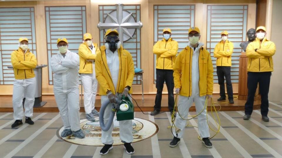 Un groupe de ministres volontaires avec des masques et des manteaux jaunes.
