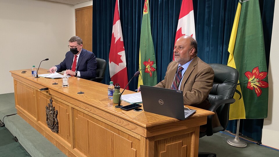 Le médecin hygiéniste en chef de la Saskatchewan, Saqib Shahab, accompagné du premier ministre de la Saskatchewan, Scott Moe lors d'une conférence de presse.