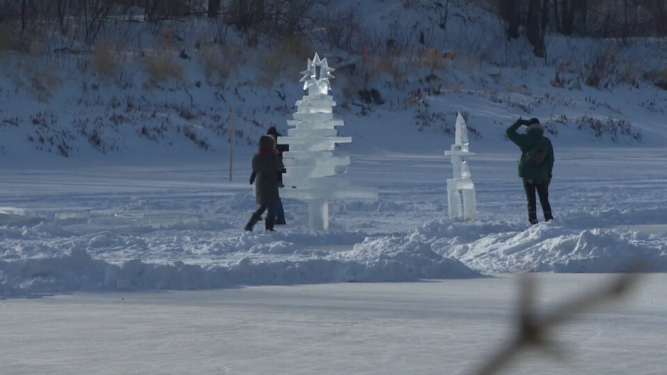 Une partie de la longue patinoire avec deux sculptures et des personnes.