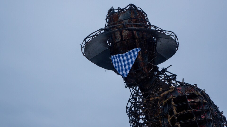 La tête de Jos Montferrand en sculpture de métal avec un masque.