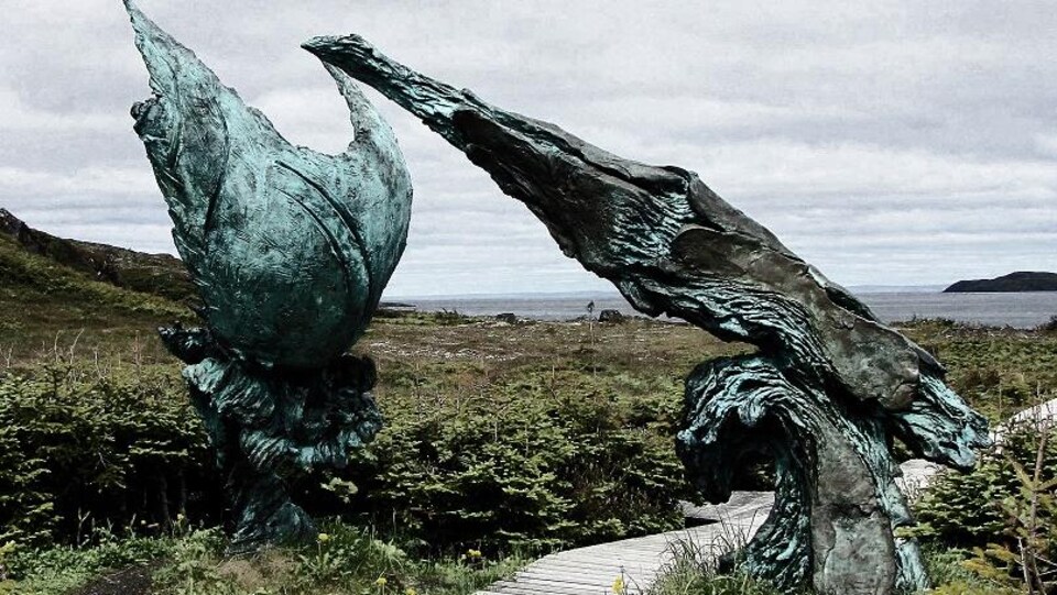 Une sculpture en bronze sur le bord de la mer.