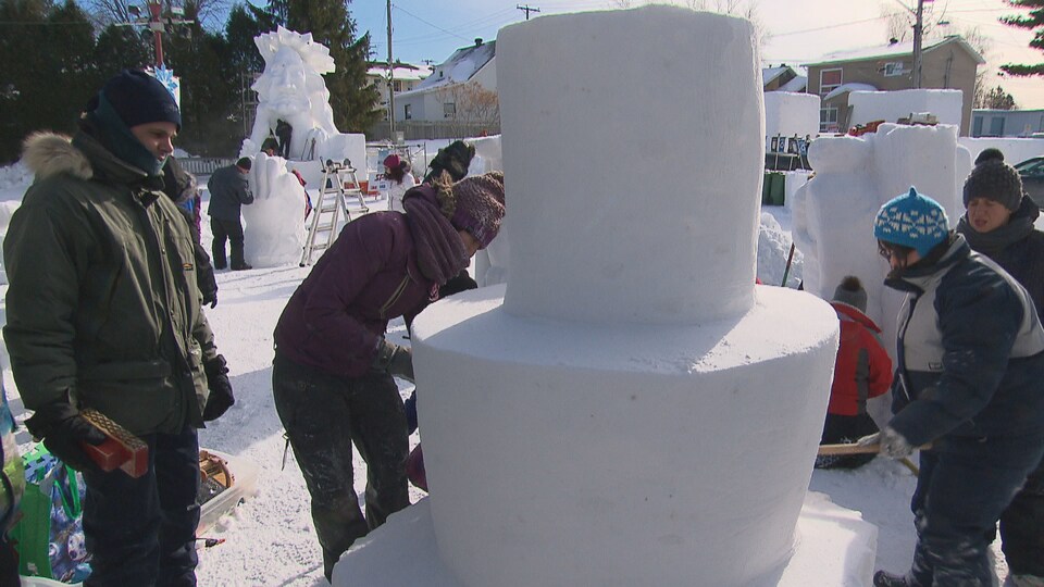 Plusieurs personnes qui sculptent dans la neige