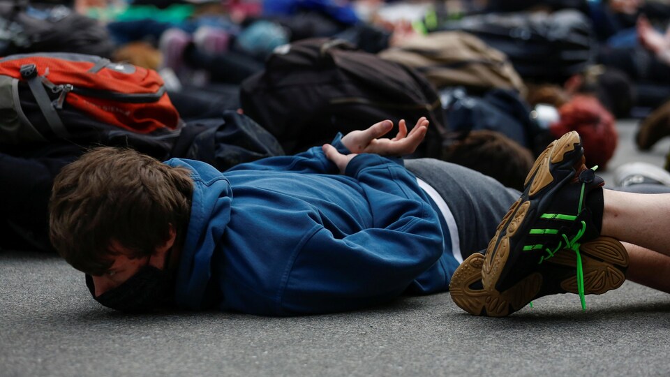 Des manifestants sont couchés au sol, les mains dans le dos.