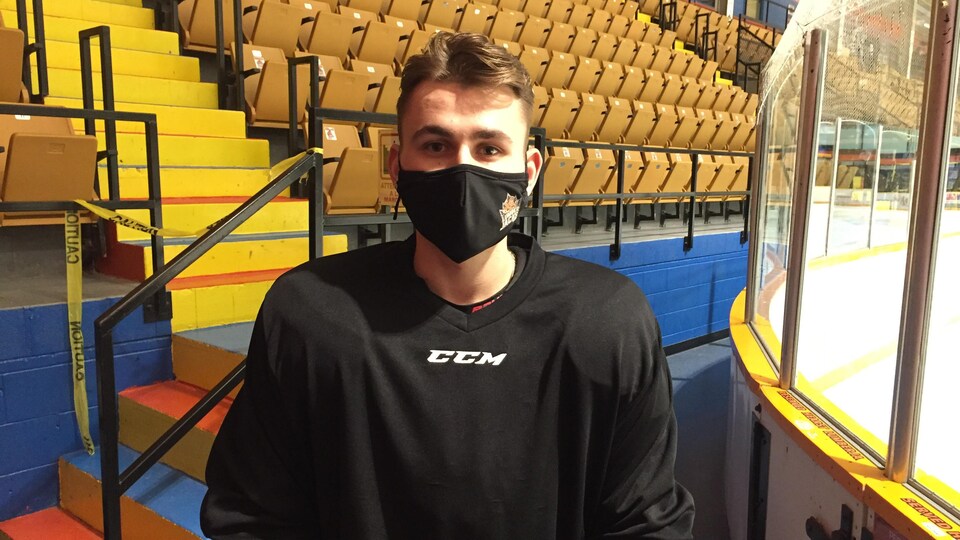 Un joueur de hockey qui porte un masque à l'extérieur de la glace.