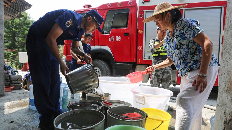 Des pompiers livrent de l'eau aux communautés touchées par la canicule.