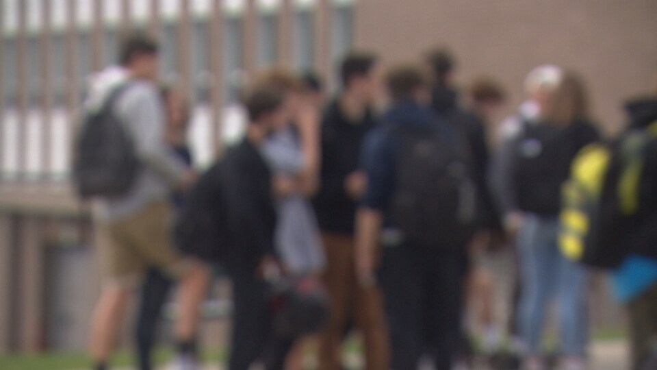 Un groupe de jeunes se déplacent côte-à-côtes.