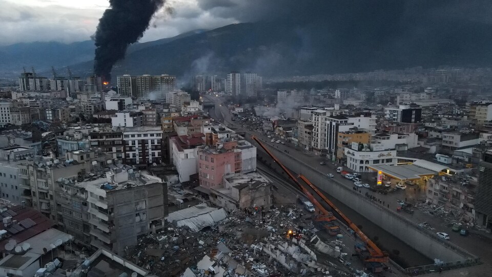 La fumée noire d'un incendie s'élève au-dessus d'Iskenderun, suite à un tremblement de terre en Turquie, le 7 février 2023.