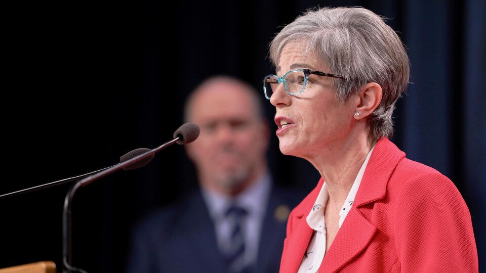 La ministre Selina Robinson avec le premier ministre John Horgan en arrière-plan.