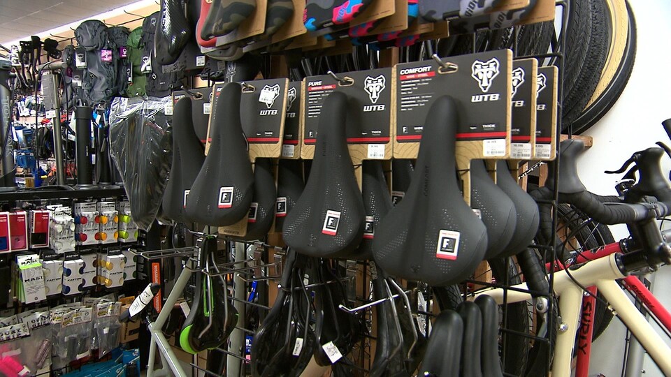 Des selles de vélo accrochées dans une boutique.