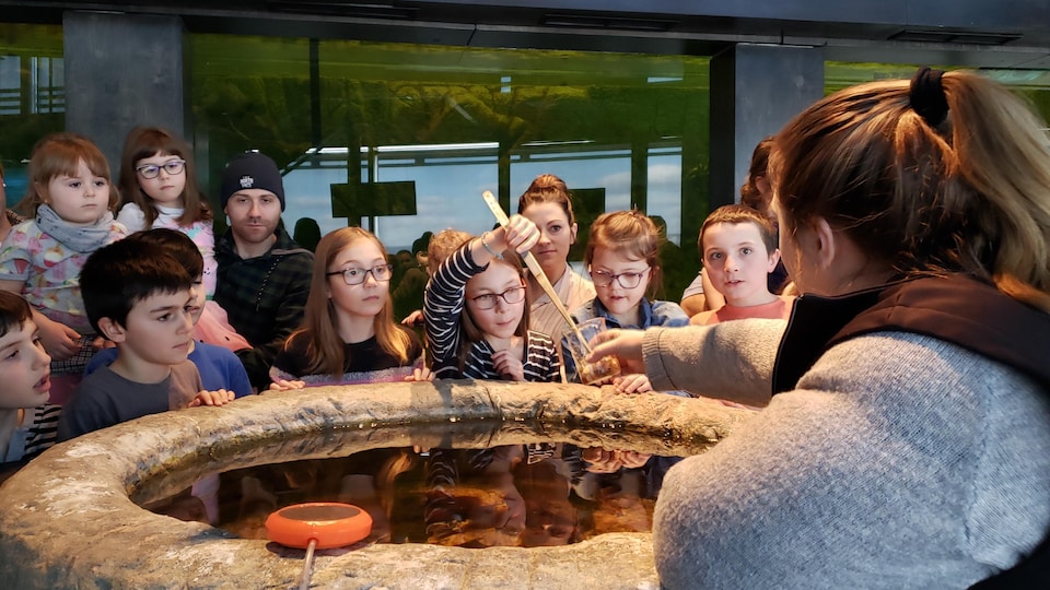 Des enfants écoutent une animatrice du Musée du Fjord.