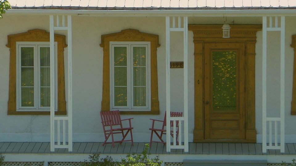 Balcon d'une maison de ferme avec deux chaises vides