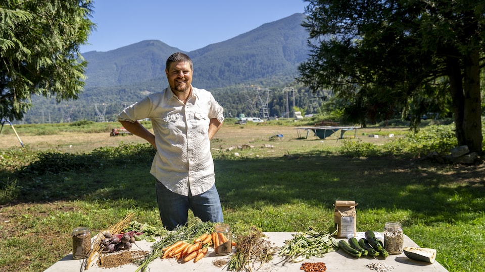 Niklaus Forstbauer devant une table avec des légumes et des semences.