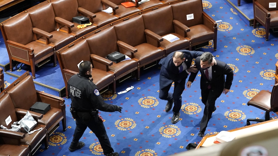 Des élus fuyant la salle du Sénat après l'intrusion des manifestants pro Trump