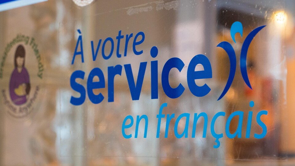 Une étiquette dans une fenêtre où l'on peut lire « À votre service en français ».