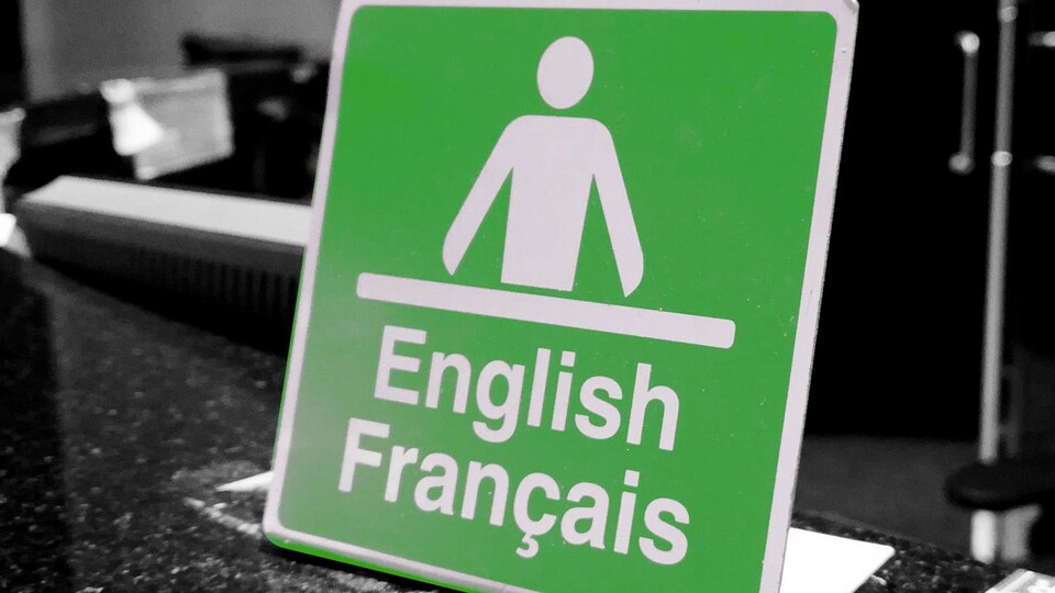 Une affiche où est écrit English Français, avec l'icône d'un homme devant un bureau.