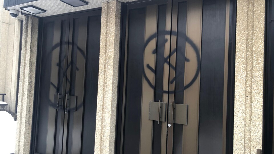 Des croix gammées peintes sur les portes d'une synagogue.
