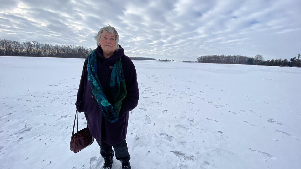 Une femme dans un champ de maïs couvert de neige.