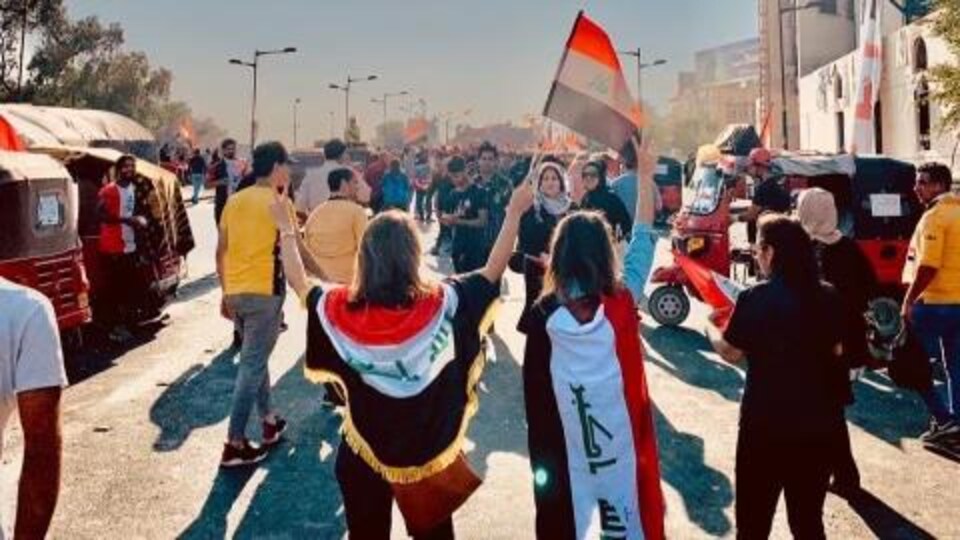 Shayma Alaldabagh brandit un drapeau irakien lors d'une manifestation à Bagdad. 