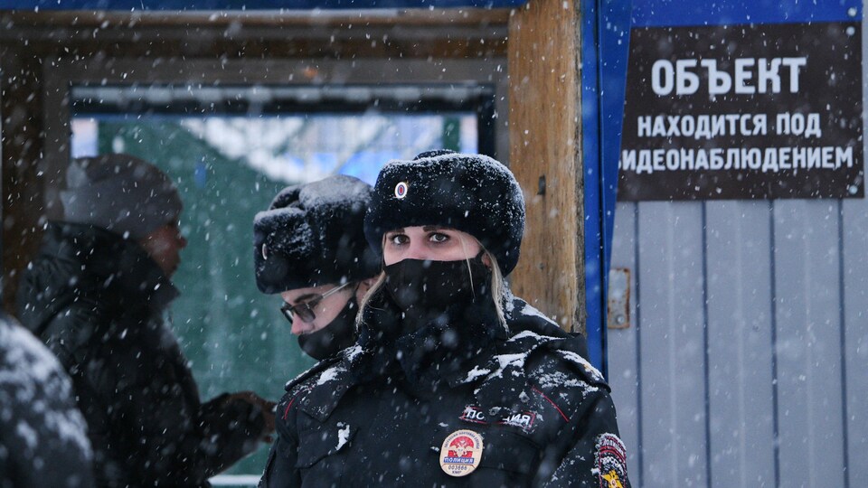 Des policiers patrouillent sous la neige.