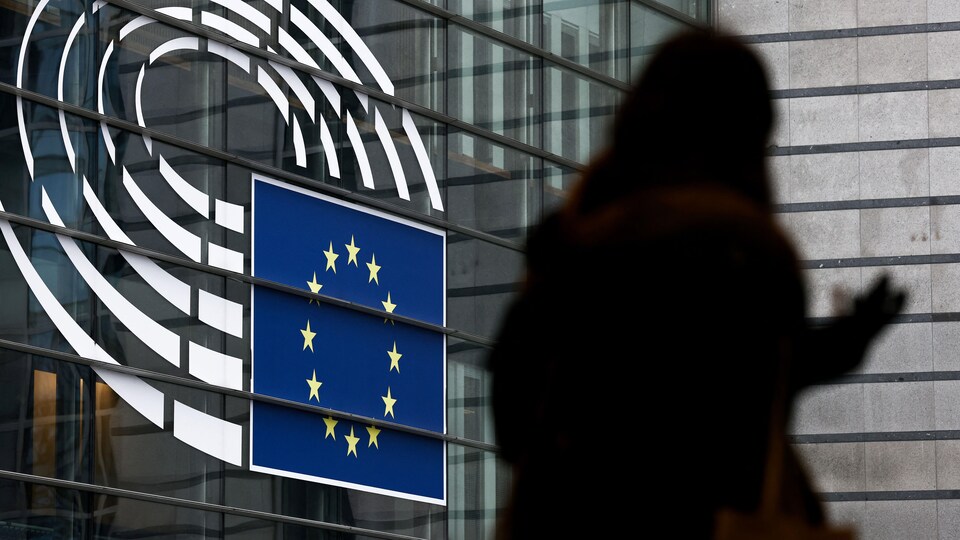 Une femme marche près de l'entrée du Parlement européen à Bruxelles.