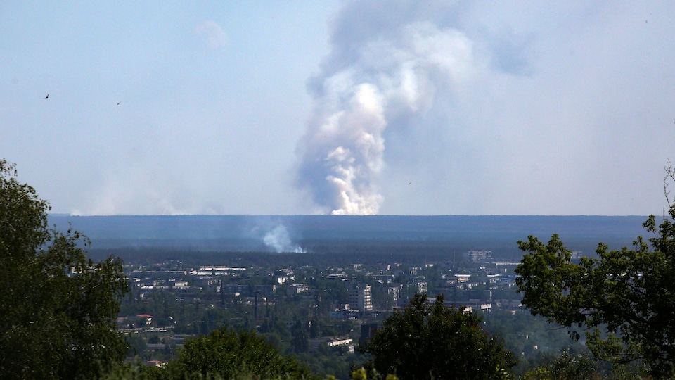 Un grand panache de fumée s'élève à l'horizon, derrière la ville de Sievierodonetsk. 