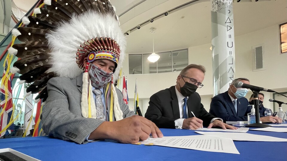 Le chef de la FSIN, Bobby Cameron, et le ministre saskatchewanais Jim Reiter signent une entente au sujet des casinos en ligne.