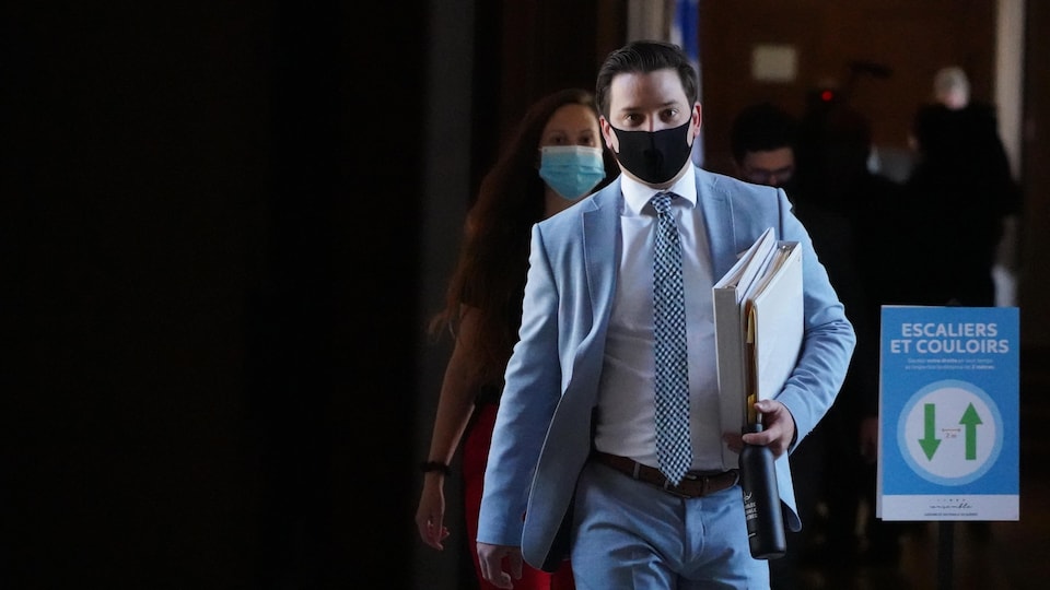 Simon Jolin-Barrette marche dans les corridors de l'Assemblée nationale en portant un masque.