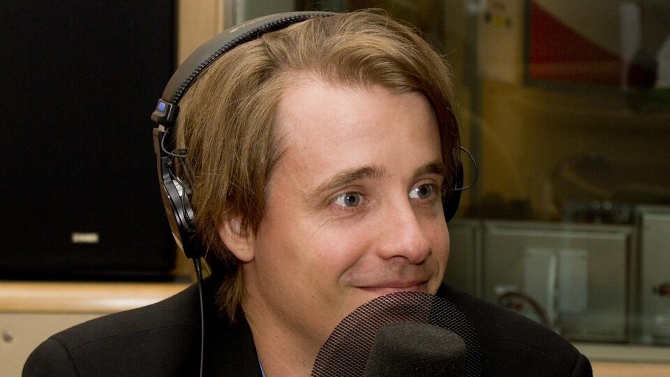 L'économiste Simon Tremblay-Pepin derrière un micro lors d'un passage dans les studios de Radio-Canada.