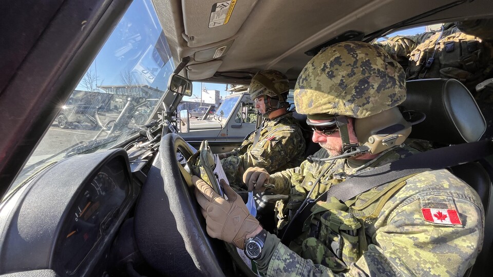 Des membres des Forces armées à bord d'un véhicule. 
