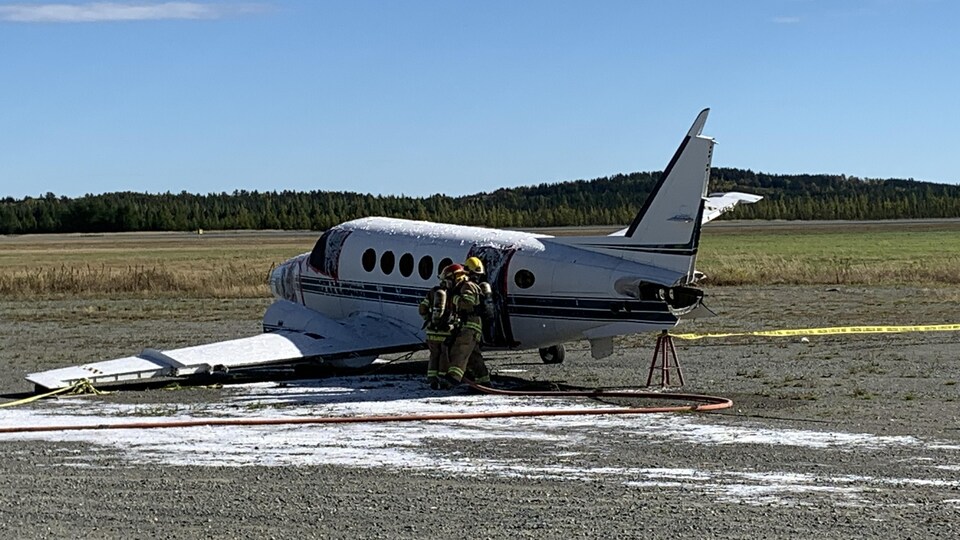 Des pompiers pénètrent dans un petit avion.