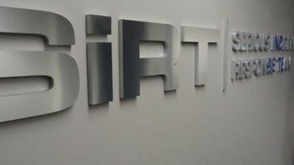 Le sigle du bureau de la SiRT sur un mur.