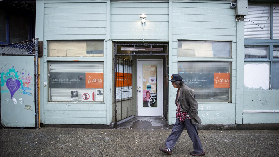 Une personne marche devant le centre d'injection supervisée SisterSpace dans le quartier du Down Town East Side.