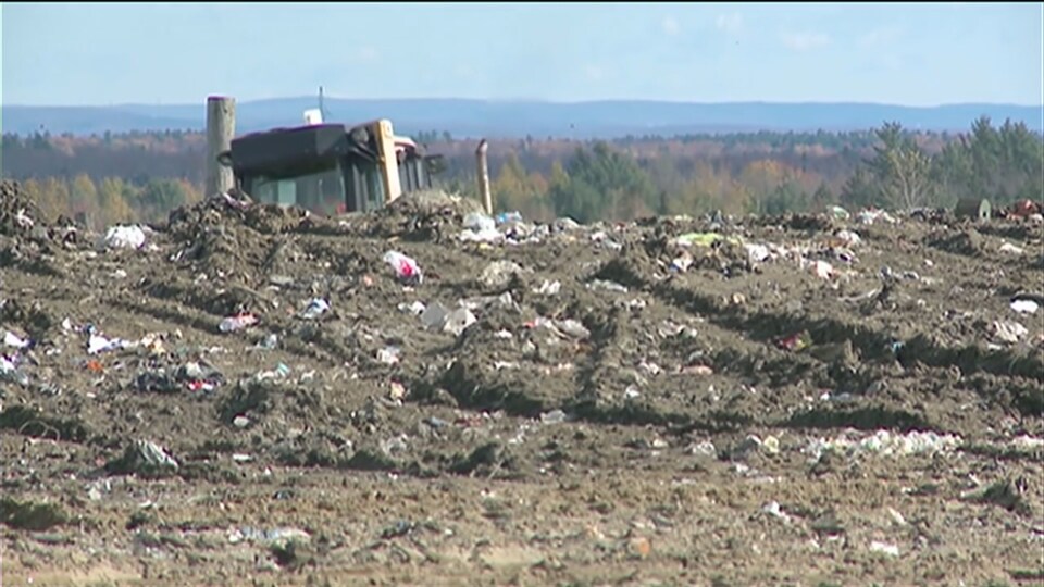 Un camion étale les déchets.