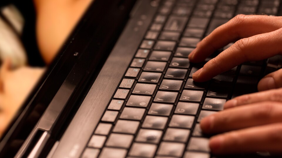 Une paire de mains sur un clavier.