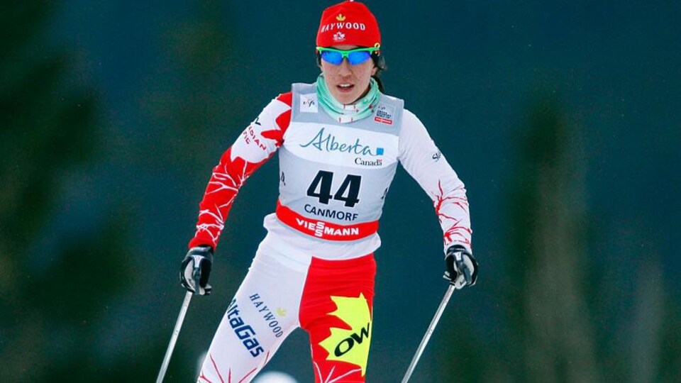 Femme vêtue de vêtements pour faire du ski de fond avec des lunettes.