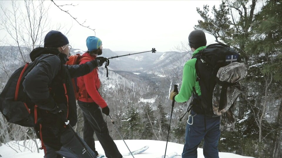 Skieurs au sommet d'une montagne regardent l'horizon