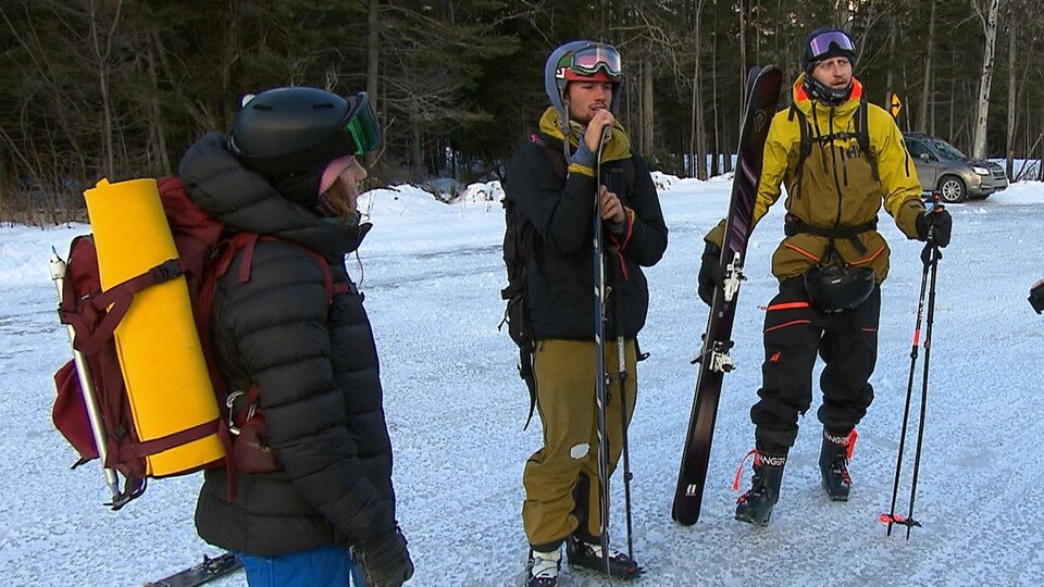 Des skieurs munis de leur équipement discutent entre eux.
